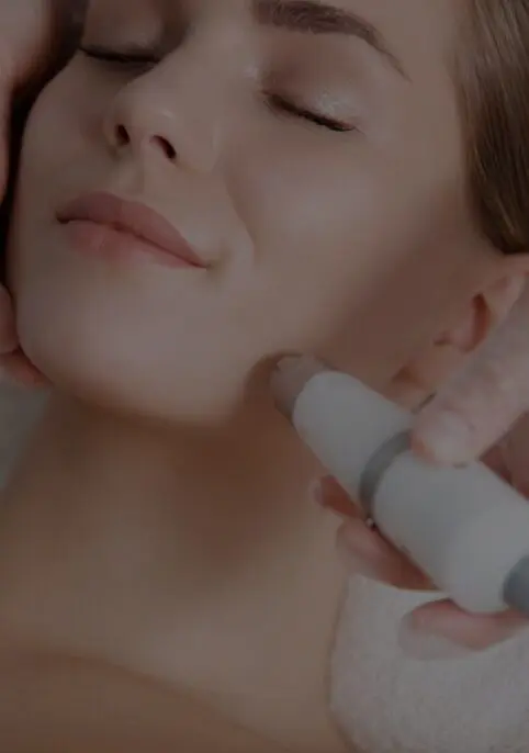A woman getting her face waxed with an electric device.